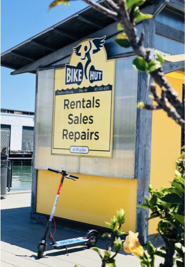 A rental shop with a Go X scooter parked out front